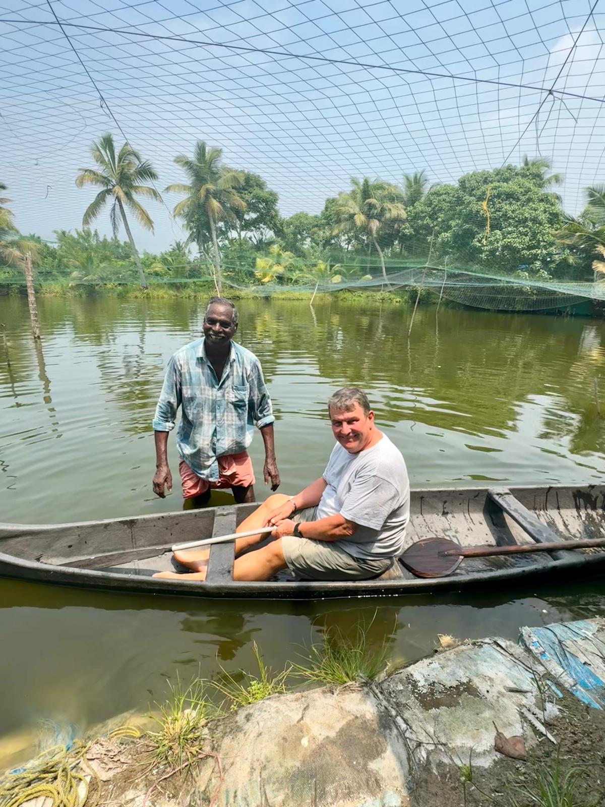 Matt in a wooden canoe with a local boatman